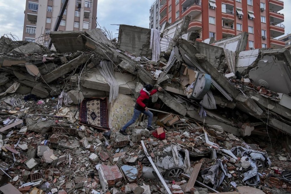 A man walks among rubble as he searches for people in a destroyed building in Adana, Turkey, Monday, Feb. 6, 2023. Prime Minister Justin Trudeau says Canada “stands ready” to provide help after a powerful earthquake toppled buildings and killed thousands of people in Turkey and Syria. THE CANADIAN PRESS/AP/Khalil Hamra