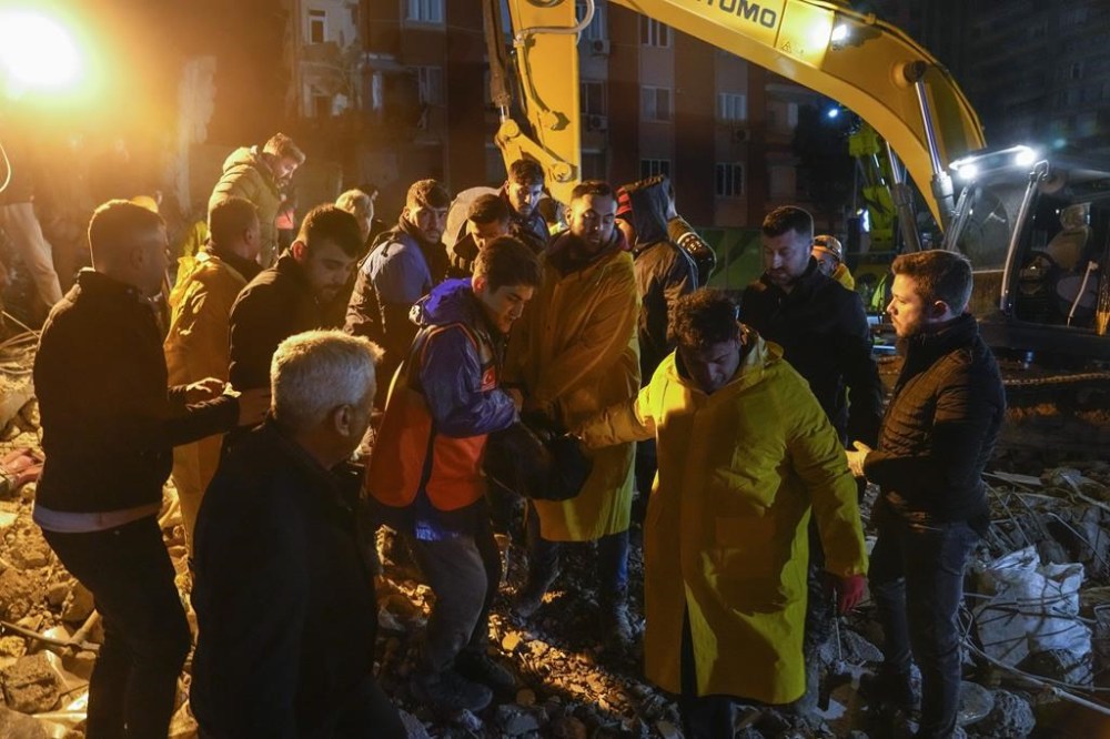 Emergency team members carry a body of a person found in the rubble of a destroyed building in Adana, Turkey, Monday, Feb. 6, 2023. A powerful earthquake that struck southeast Turkey and northern Syria has killed more than 640 people with hundreds injured. The toll is expected to rise as rescuers search for dead and survivors in dozens of collapsed buildings across the region. (AP Photo/Khalil Hamra)