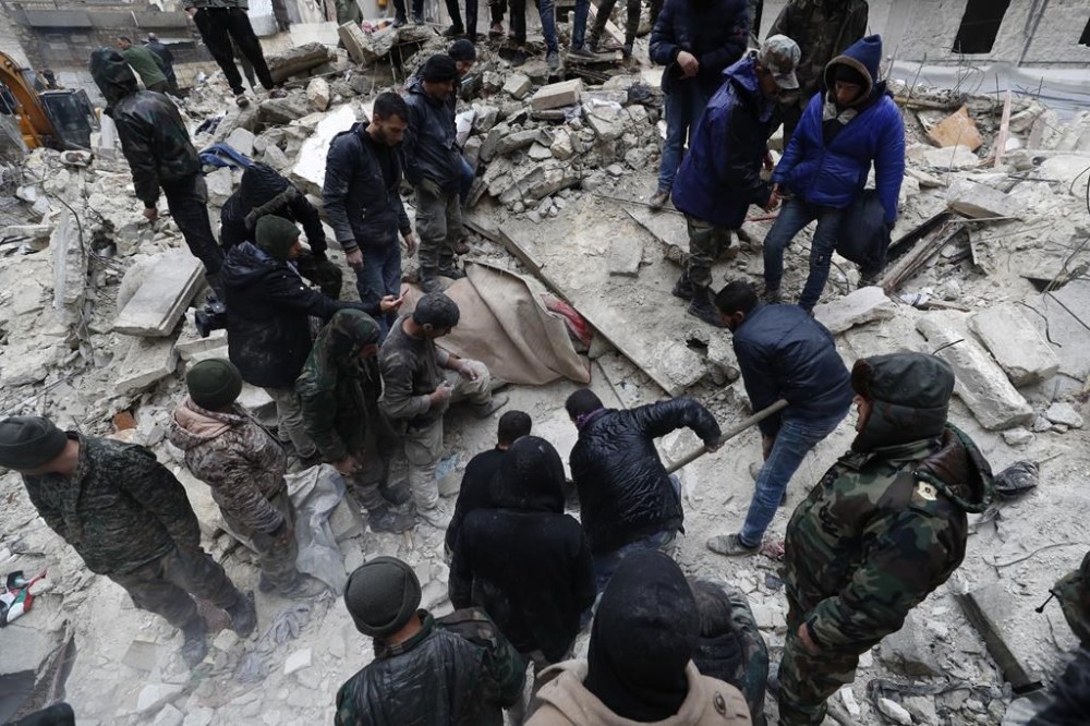 Syrian Civil Defense workers and security forces search through the wreckage of collapsed buildings, in Aleppo, Syria, Monday, Feb. 6, 2023. A powerful earthquake rocked wide swaths of Turkey and neighboring Syria on Monday, toppling hundreds of buildings and killing and injuring thousands of people. (AP Photo/Omar Sanadiki)