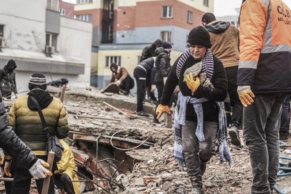 People and emergency teams search for people in the rubble in a destroyed building in Gaziantep, Turkey, Monday, Feb. 6, 2023. A powerful quake has knocked down multiple buildings in southeast Turkey and Syria and many casualties are feared. (AP Photo/Mustafa Karali)