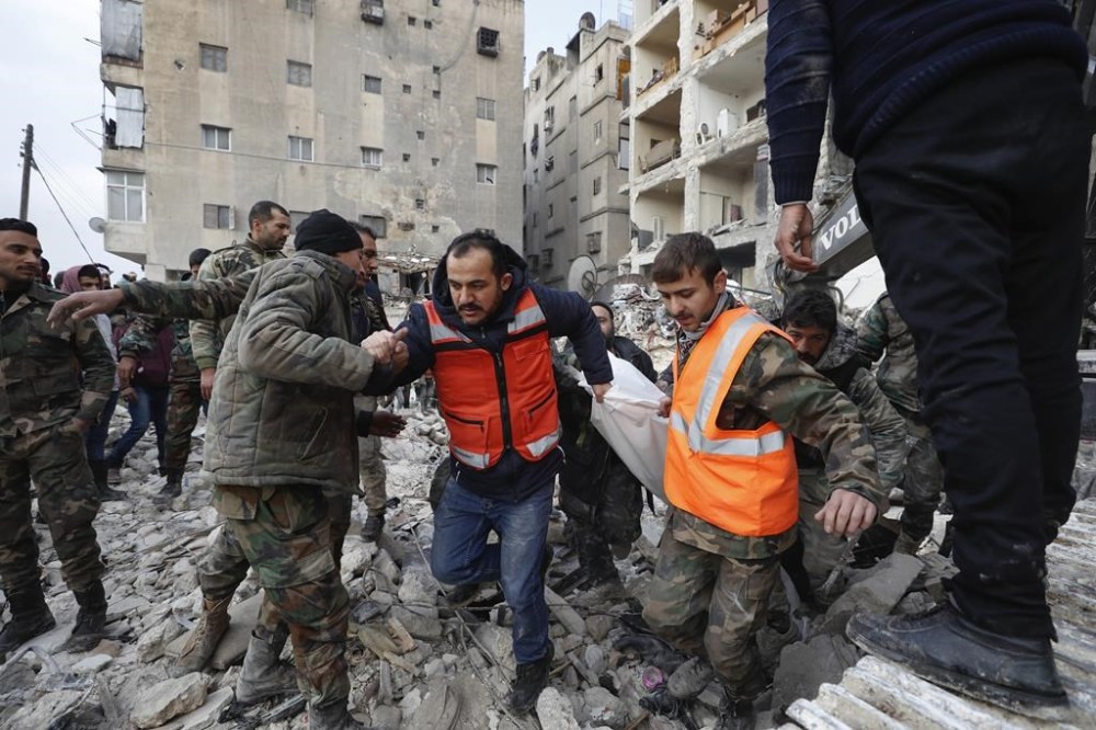 Rescue teams carry the body of a victim from a destroyed building in Aleppo, Syria, Tuesday, Feb. 7, 2023. Rescuers raced Tuesday to find survivors in the rubble of thousands of buildings brought down by a powerful earthquake and multiple aftershocks that struck eastern Turkey and neighboring Syria. (AP Photo/Omar Sanadiki)