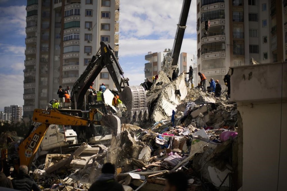 Emergency rescue members search for people in a destroyed building in Adana, Turkey on Tuesday. (Francisco Seco / The Associated Press)