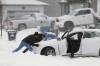 Manitobans don’t drive past a car stuck in the snow. A passerby stops, then another, and soon there’s a whole crowd gathered. (John Woods / The Canadian Press files)