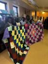 Rebecca Deng (left) with a quilt made at the the Excel Empowerment Centre in Winnipeg. (Supplied)