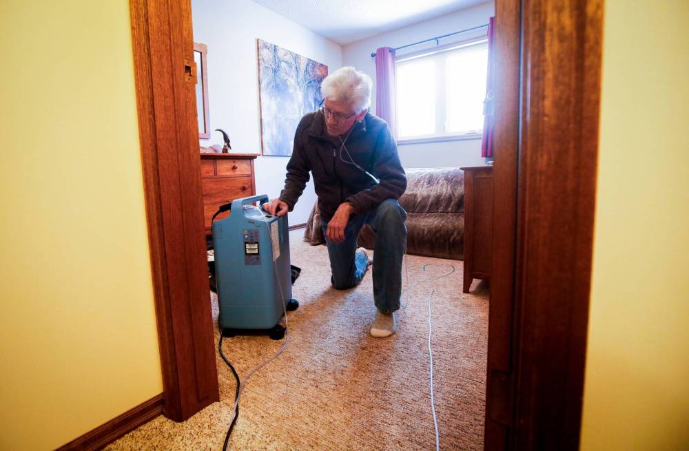 JOHN WOODS / WINNIPEG FREE PRESS
Rick Schmidt adjusts his oxygen machine at his home: ‘It feels like my life has shrunk to the size of a shoe box.’