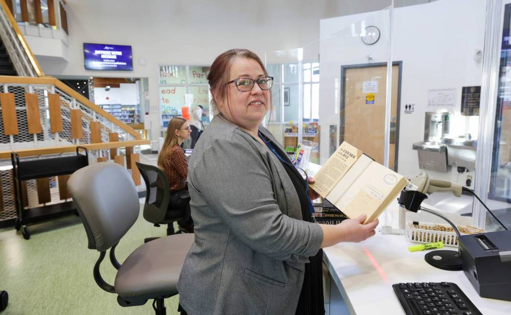 RUTH BONNEVILLE / WINNIPEG FREE PRESS
Barbara Bourrier-LaCroix, administrative co-ordinator of collections and borrower services at Winnipeg Public Library, with the book open showing stamped date of when it should have been returned.
