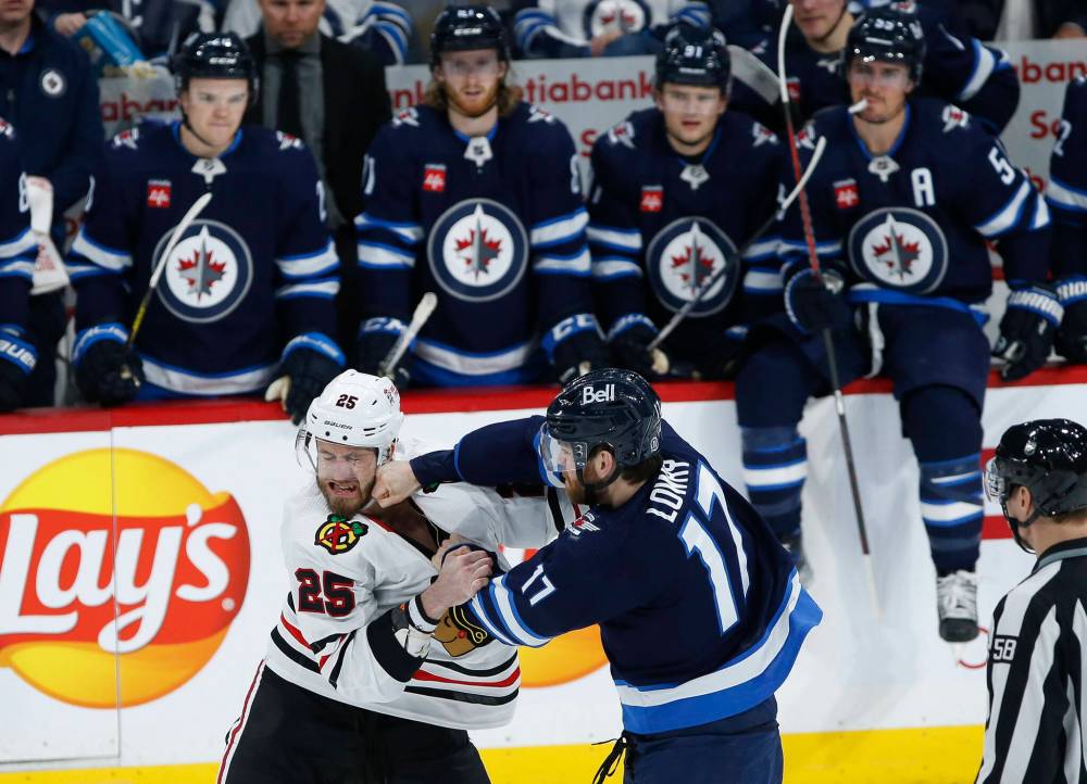 JOHN WOODS / THE CANADIAN PRESS
Winnipeg Jets’ Adam Lowry (17) and Chicago Blackhawks’ Jarred Tinordi (25) fight during the third period.