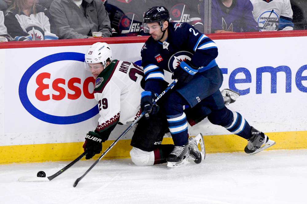 FRED GREENSLADE / CANADIAN PRESS FILES
Winnipeg Jets defenceman Dylan DeMelo, seen here introducing Barrett Hayton of the Arizona Coyotes to the boards at Canada Life Centre, is expected to be back on the Jets’ blue line against the Seattle Kraken after missing three games with an injury.