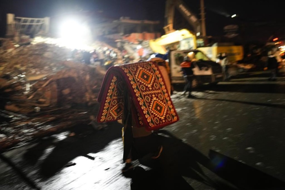 A man bring blankets and mattress as rescue teams search for people in destroyed buildings in Elbistan, southern Turkey, Wednesday, Feb. 8, 2023. With the hope of finding survivors fading, stretched rescue teams in Turkey and Syria searched Wednesday for signs of life in the rubble of thousands of buildings toppled by a catastrophic earthquake. (AP Photo/Francisco Seco)