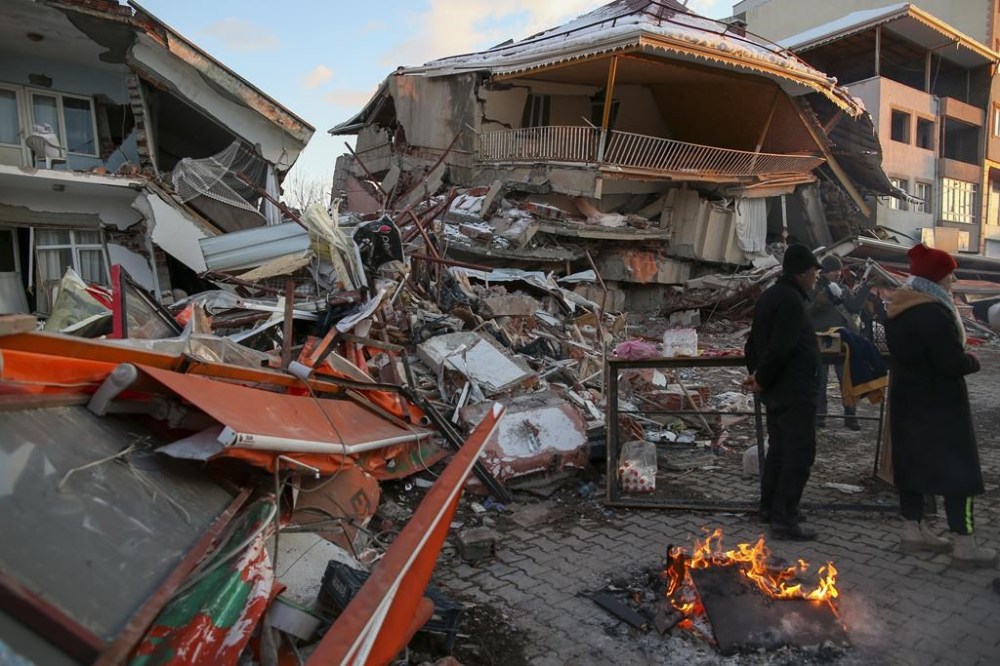 People stand by collapsed buildings in Golbasi, in Adiyaman province, southern Turkey, Wednesday, Feb. 8, 2023. A team of urban search and rescue specialists from British Columbia has deployed to Turkey's earthquake zone after independently offering to help with what one Turkish official described as a race against time to find survivors in frigid conditions. THE CANADIAN PRESS/AP, Emrah Gurel