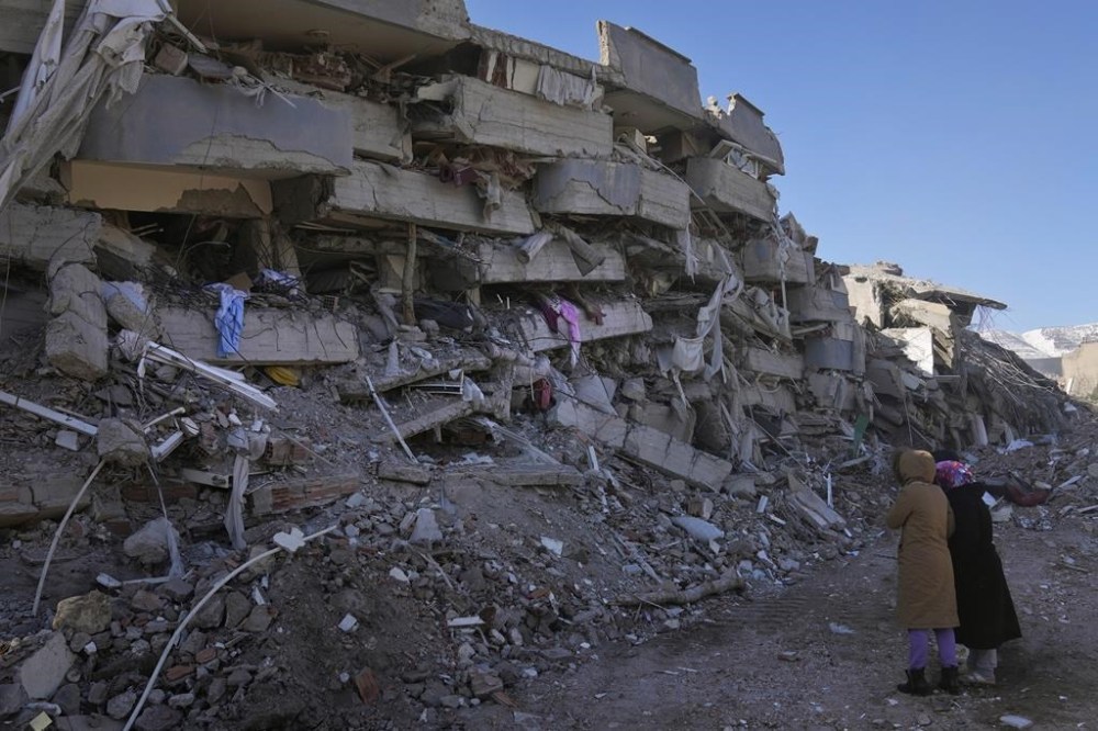 Women from Turkey check their destroyed building, in Kahramanmaras, southern Turkey, Wednesday, Feb. 8, 2023. With the hope of finding survivors fading, stretched rescue teams in Turkey and Syria searched Wednesday for signs of life in the rubble of thousands of buildings toppled by a catastrophic earthquake. (AP Photo/Hussein Malla)