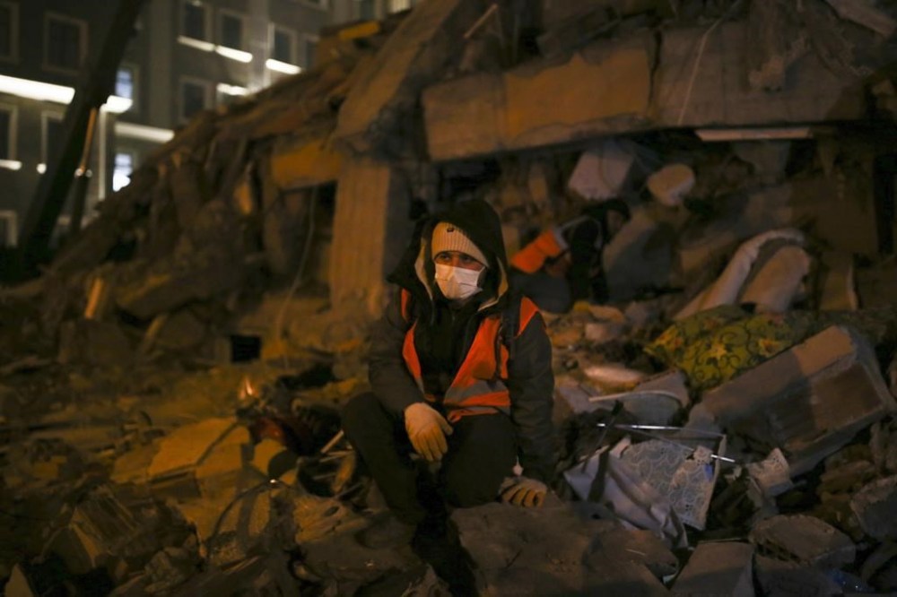 A man sits in front of a destroyed building, in Adiyaman, southeastern Turkey, Wednesday, Feb. 8, 2023. With hope of finding survivors fading, stretched rescue teams in Turkey and Syria searched Wednesday for signs of life in the rubble of thousands of buildings toppled by the world's deadliest earthquake in more than a decade. (AP Photo/Emrah Gurel)