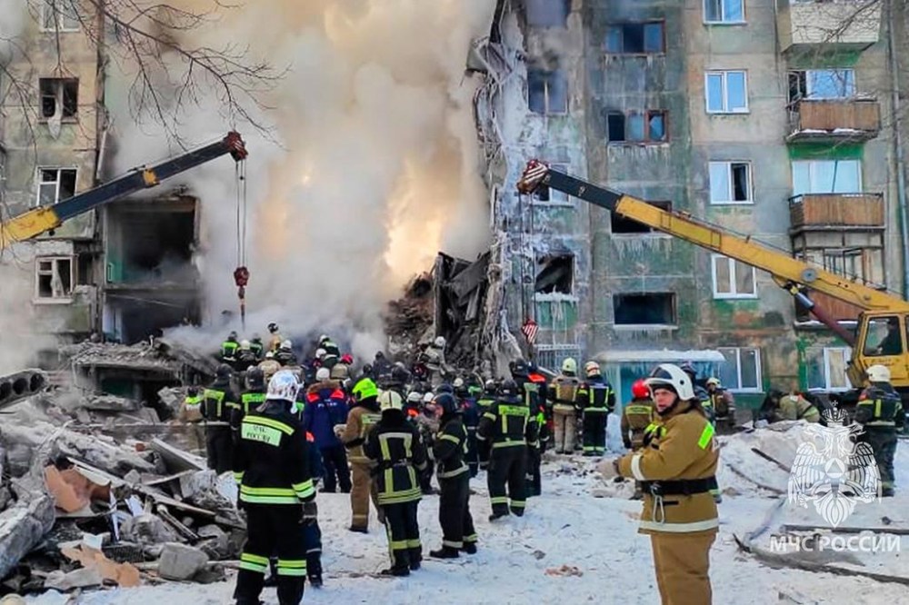 In this photo released by the Russian Emergency Ministry Press Service, Emergency service employees work at a site of a five-story residential building collapsed after a gas explosion in the Siberian city of Novosibirsk, Russia, Thursday, Feb. 9, 2023. Authorities say a gas explosion in an apartment building in the Siberian city of Novosibirsk has killed at least five people including a 2-year-old child. The explosion at 7:43 a.m. on Thursday caused two entrances of the five-story building to collapse, with 30 apartments destroyed by the ensuing fire. (Russian Emergency Ministry Press Service via AP)
