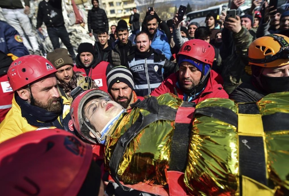 Rescuers carry Zeynep Polat, pulled out from a collapsed building days after the earthquake, in Kahramanmaras, southern Turkey, Thursday, Feb. 9, 2023. Thinly stretched rescue teams worked through the night in Turkey and Syria, pulling more bodies from the rubble of thousands of buildings toppled by a catastrophic earthquake. (Ismail Coskun/IHA via AP)