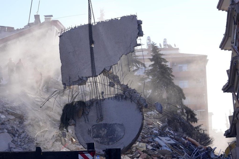 A crane removes debris as rescuers search on a destroyed building in Gaziantep, southeastern Turkey, Thursday, Feb. 9, 2023. Rescuers pulled more survivors from beneath the rubble of collapsed buildings Thursday, but hopes were starting to fade of finding many more people alive more than three days after a catastrophic earthquake and series of aftershocks hit Turkey and Syria. (AP Photo/Kamran Jebreili)