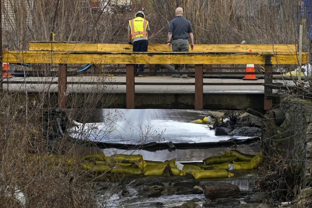 HEPACO workers, an environmental and emergency services company, observe a stream in East Palestine, Ohio, Thursday, Feb. 9, 2023 as the cleanup continues after the derailment of a Norfolk Southern freight train Friday. (AP Photo/Gene J. Puskar)