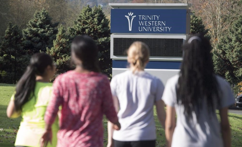Immigration data suggest tens of thousands of Chinese students in Canada may have returned to China during the pandemic. But now Canadian universities and officials say they are getting ready to welcome some back, after the Chinese government ordered students taking online classes with foreign universities to return to foreign campuses. People walk past a sign at Trinity Western University in Langley, B.C. Tuesday, Nov. 1, 2016. THE CANADIAN PRESS/Jonathan Hayward