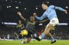 Manchester City's Jack Grealish, right, kicks the ball ahead of Aston Villa's Ashley Young during the English Premier League soccer match between Manchester City and Aston Villa at the Etihad Stadium in Manchester, England, Sunday, Feb. 12, 2023. (AP Photo/Dave Thompson)