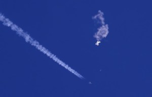 FILE - In this photo provided by Chad Fish, the remnants of a large balloon drift above the Atlantic Ocean, just off the coast of South Carolina, with a fighter jet and its contrail seen below it, Feb. 4, 2023. A missile fired on Feb. 5 by a U.S. F-22 off the Carolina coast ended the days-long flight of what the Biden administration says was a surveillance operation that took the Chinese balloon near U.S. military sites. It was an unprecedented incursion across U.S. territory for recent decades, and raised concerns among Americans about a possible escalation in spying and other challenges from rival China. (Chad Fish via AP, File)