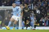 Manchester City's Erling Haaland, left, kicks the ball ahead of Aston Villa's Boubacar Kamara, centre, and Aston Villa's Emiliano Buendia during the English Premier League soccer match between Manchester City and Aston Villa at the Etihad Stadium in Manchester, England, Sunday, Feb. 12, 2023. (AP Photo/Dave Thompson)