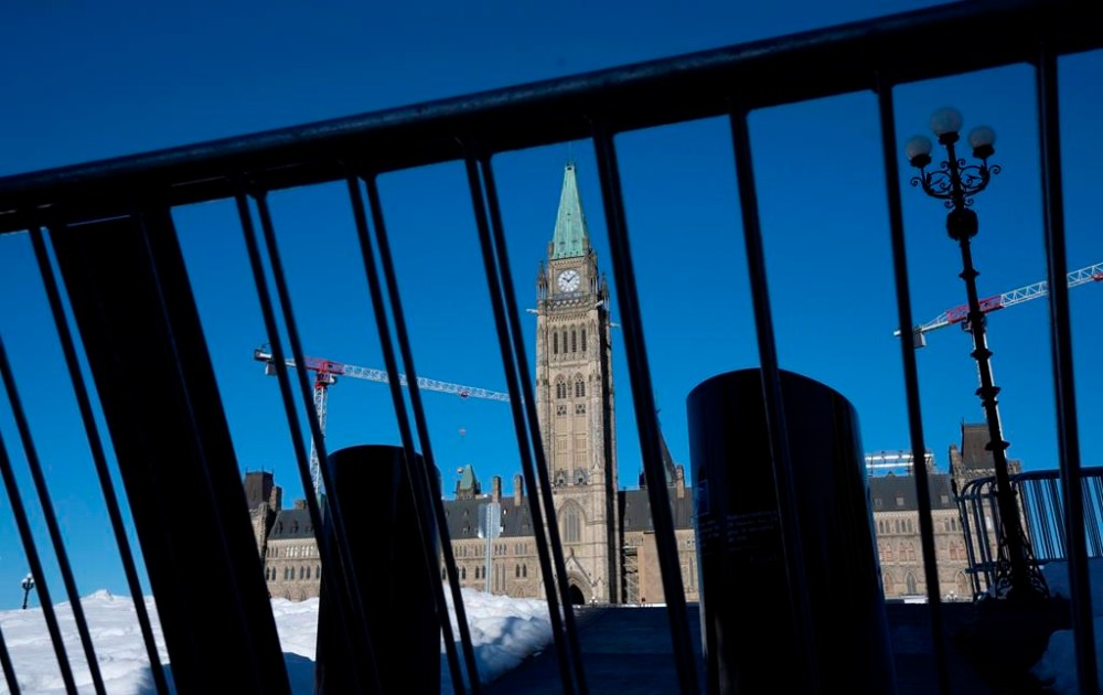 Protesters returned to Ottawa in significantly smaller numbers today to mark the one-year anniversary of the Liberal government's invocation of the Emergencies Act. Increased temporary security measures are seen blocking access to Parliament Hill, Tuesday, Feb. 14, 2023 in Ottawa.THE CANADIAN PRESS/Adrian Wyld
