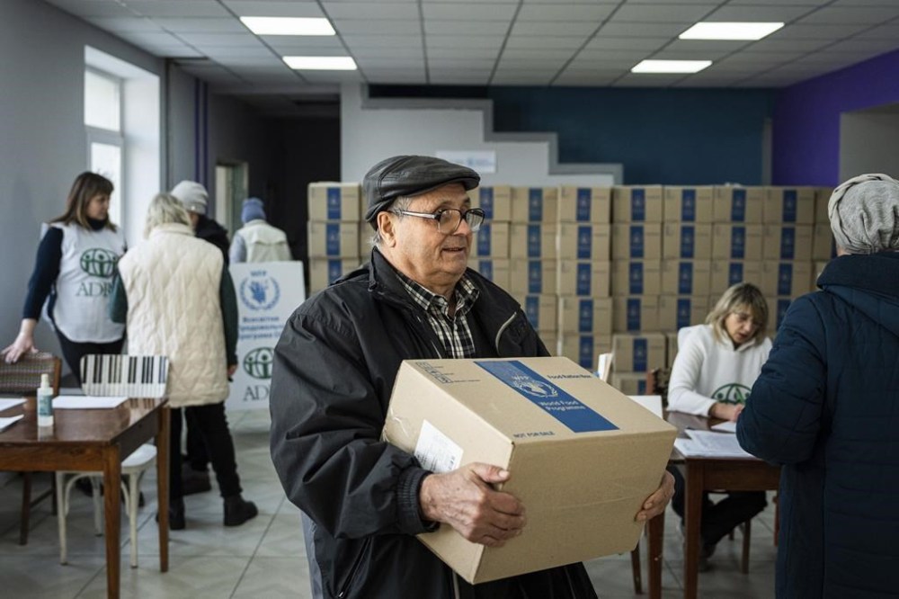 A man receives humanitarian aid provided by UN World Food Program and ADRA charity organisation for the residents of the region and internally displaced persons at the distribution center in Kostiantynivka, Ukraine, Friday, Feb. 10, 2023. (AP Photo/Evgeniy Maloletka)