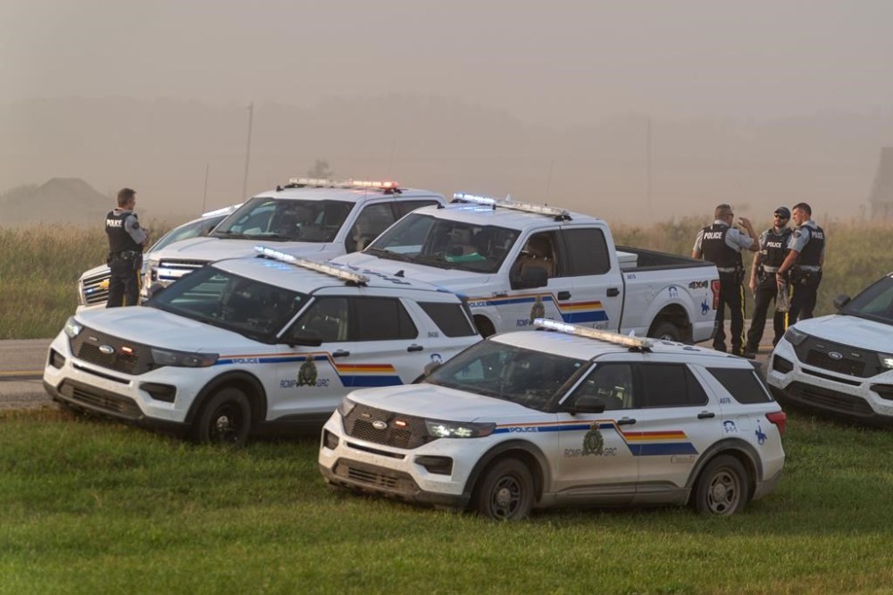 Police and investigators are seen at the side of the road outside Rosthern, Sask., on Wednesday, Sept. 7, 2022. RCMP say Myles Sanderson, a suspect in a deadly stabbing rampage northeast of Saskatoon over the weekend, has been taken into custody near the town of Rosthern on the fourth day of a massive manhunt. Inquests examining the Saskatchewan stabbing rampage that left 11 people dead and 18 injured are tentatively scheduled to take place early next year. THE CANADIAN PRESS/Heywood Yu