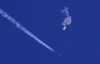 In this photo provided by Chad Fish, the remnants of a large balloon drift above the Atlantic Ocean, just off the coast of South Carolina, with a fighter jet and its contrail seen below it, Feb. 4, 2023. After four flying objects were discovered, tracked and shot down over U.S. and Canadian airspace in recent weeks, some politicians and researchers say the incidents highlight the need to improve security in Canada's Arctic. THE CANADIAN PRESS/Chad Fish via AP