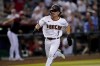 FILE - Arizona Diamondbacks' Corbin Carroll scores on a double by Carson Kelly during the fourth inning of a baseball game against the Philadelphia Phillies, Monday, Aug. 29, 2022, in Phoenix. Baltimore Orioles infielder Gunnar Henderson and Arizona Diamondbacks outfielder Corbin Carroll are among the majors' most promising rookies heading into the season. (AP Photo/Matt York, File)