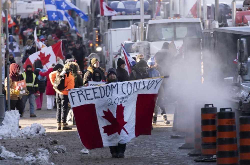 Protesters participating in a cross-country truck convoy protesting measures taken by authorities to curb the spread of COVID-19 and vaccine mandates walk near Parliament Hill in Ottawa on Saturday, Jan. 29, 2022. THE CANADIAN PRESS FILES /Adrian Wyld
