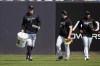 New York Yankees' Aaron Judge, left, carries a bucket of balls after fielding drills during a spring training baseball workout Monday, Feb. 20, 2023, in Tampa, Fla. (AP Photo/David J. Phillip)