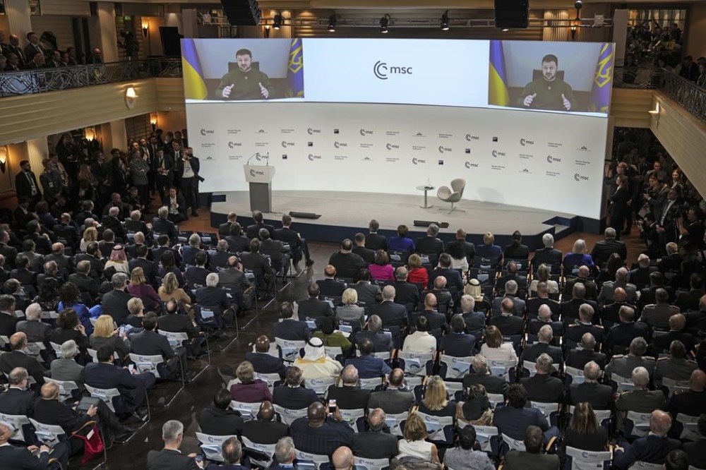 FILE - Ukraine President Volodymyr Zelenskyy speaks via video link at the Munich Security Conference in Munich, Germany, Friday, Feb. 17, 2023. A year ago, with Russian forces bearing down on Ukraine’s capital, Western leaders feared for the life of President Volodymyr Zelenskyy and the U.S. offered him an escape route. Zelenskyy declined, declaring his intent to stay and defend Ukraine’s independence. (AP Photo/Michael Probst, File)