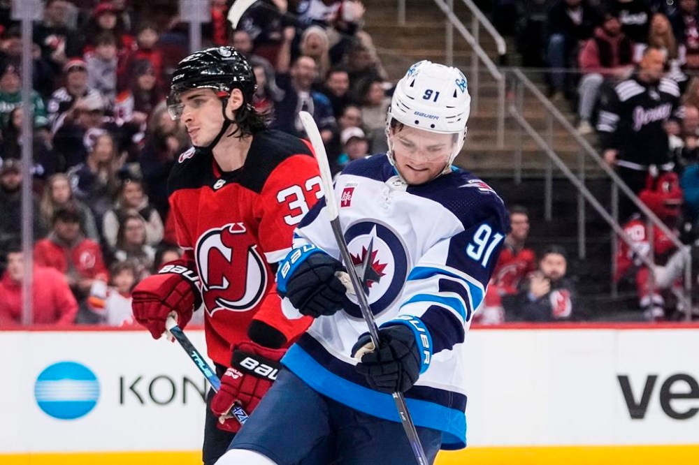 Winnipeg Jets' Cole Perfetti (91) celebrates as New Jersey Devils' Ryan Graves (33) skates past after Perfetti scored a goal during the first period of an NHL hockey game Sunday, Feb. 19, 2023, in Newark, N.J. The Winnipeg Jets placed forward Perfetti on injured reserved Tuesday. THE CANADIAN PRESS/AP-Frank Franklin II