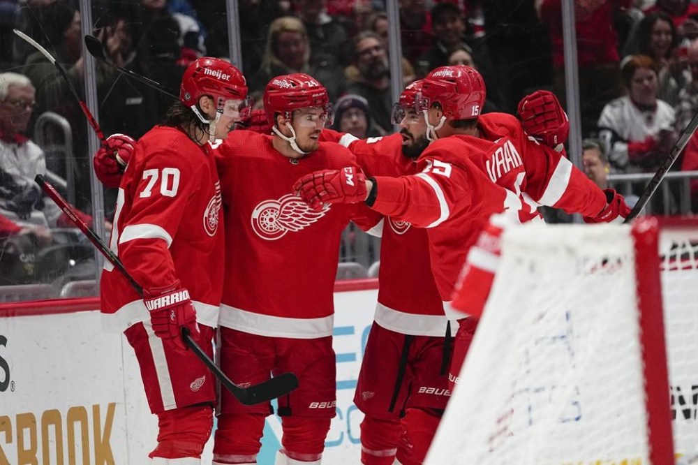 Detroit Red Wings players celebrate a goal by Pius Suter, second from left, during the third period of an NHL hockey game against the Washington Capitals, Tuesday, Feb. 21, 2023, in Washington. The Red Wigs won 3-1. (AP Photo/Julio Cortez)