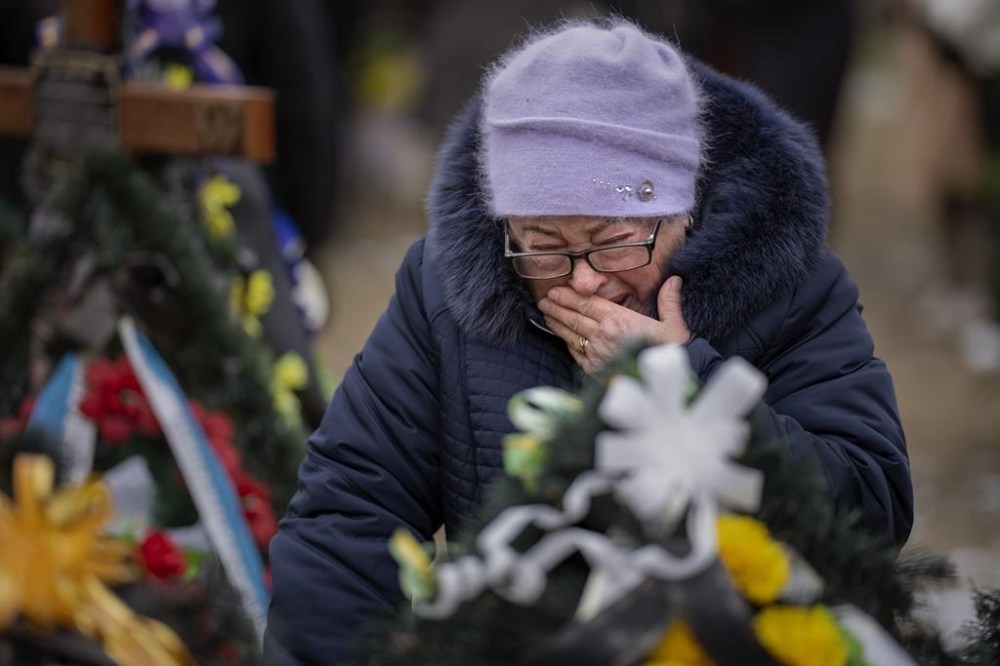 Maria Kurbet, 77, cries at the grave of her son, a military serviceman killed in Bakhmut, during a memorial service to mark the one-year anniversary of the start of the Russia Ukraine war, in a cemetery in Bucha, Ukraine, Friday, Feb. 24, 2023. (AP Photo/Emilio Morenatti)