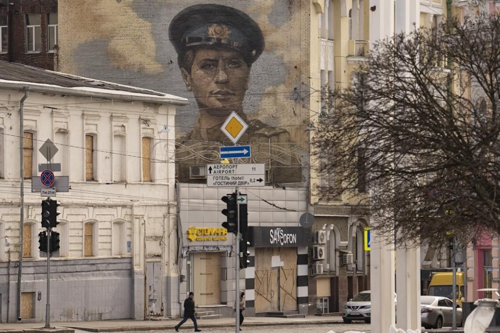People cross a street in Kharkiv, Ukraine, Friday, Feb. 24, 2023. Ukraine's leader pledged Friday to push for victory in 2023 as he and other Ukrainians marked the somber anniversary of the Russian invasion that upended their lives and Europe's security. (AP Photo/Vadim Ghirda)
