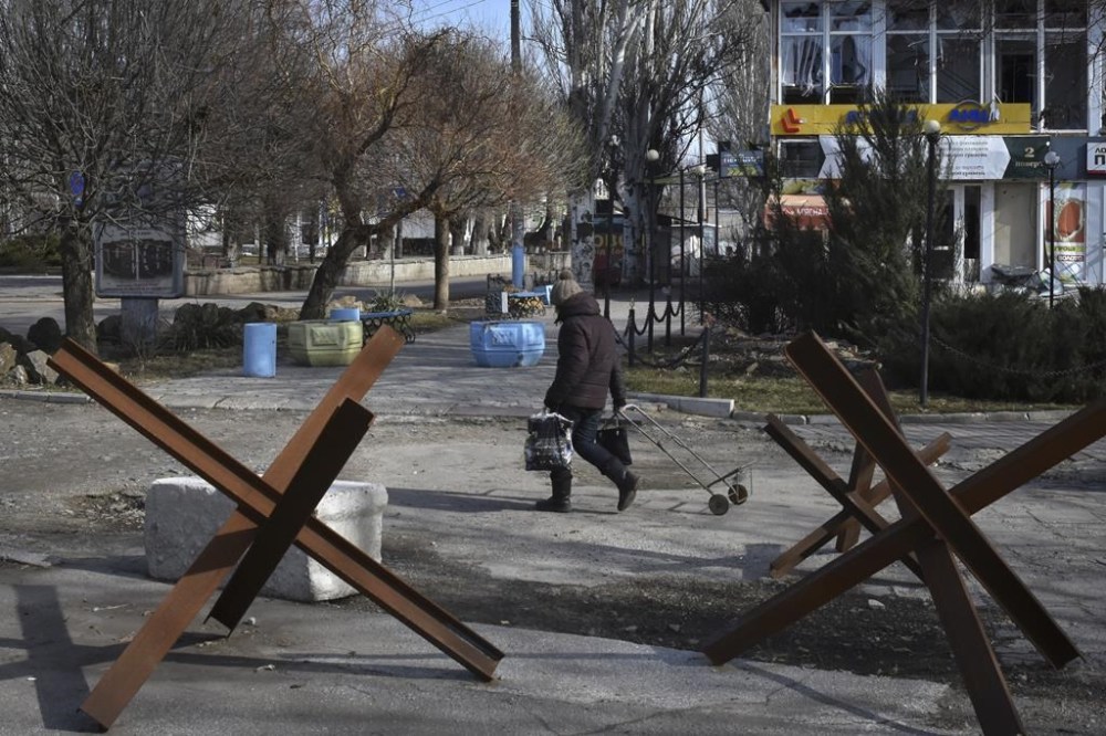 A local resident walks along a street in Orihiv, Zaporizhzhya region, Ukraine, Friday, Feb. 24, 2023. Ukraine's president pledged to push for victory in 2023 as he and other Ukrainians on Friday marked the somber first anniversary of the Russian invasion that he called