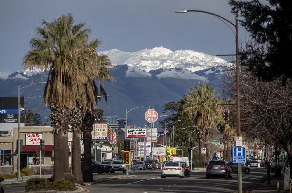 Snow-capped Mount Hamilton rises above San Jose, Calif. in a view down West San Carlos Street, Friday, Feb. 24, 2023. (Karl Mondon /Bay Area News Group via AP)