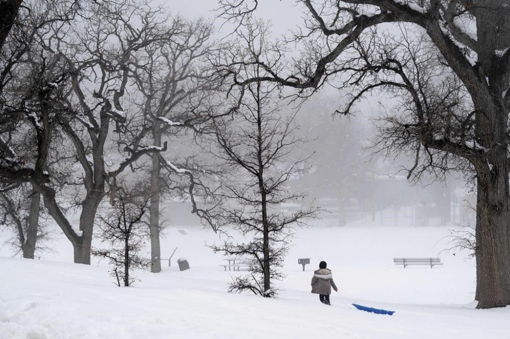 A person drags a sled through the snow at Frazier Park Monday, Feb. 27, 2023, in Calif. A winter storm warning is in effect for the area through Wednesday. (David Crane/The Orange County Register via AP)