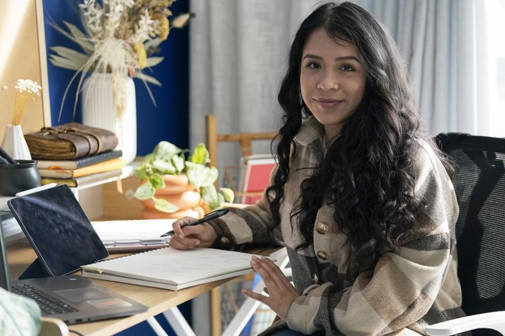 Priscilla Molina poses for a portrait in Los Angeles on Wednesday, Feb. 22, 2023. Molina designs a minimum of 300 custom signatures a month, offering packages that include up to three ways to sign, limitless drafts or a new set of initials. (AP Photo/Ashley Landis)