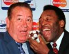 FILE - Soccer legend Pele, of Brazil, feeds French soccer legend Just Fontaine, left, with a soccer ball cake Sunday, July 5, 1998 in Paris.French soccer great Just Fontaine, whose 1958 record of 13 goals scored during a World Cup still stands, has died. He was 89. His former club Reims announced Fontaine's death on Wednesday March 1, 2023. (AP Photo/Jacques Brinon, File)