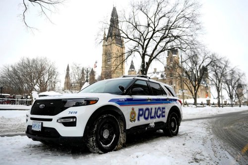 An Ottawa Police officer sits in their cruiser on Wellington Street below Parliament Hill in Ottawa, on Friday, Jan. 27, 2023. Ottawa police are committing to changing the way they respond to mental health calls as critics condemn a proposal to boost the policing budget by more than $15 million. THE CANADIAN PRESS/Justin Tang
