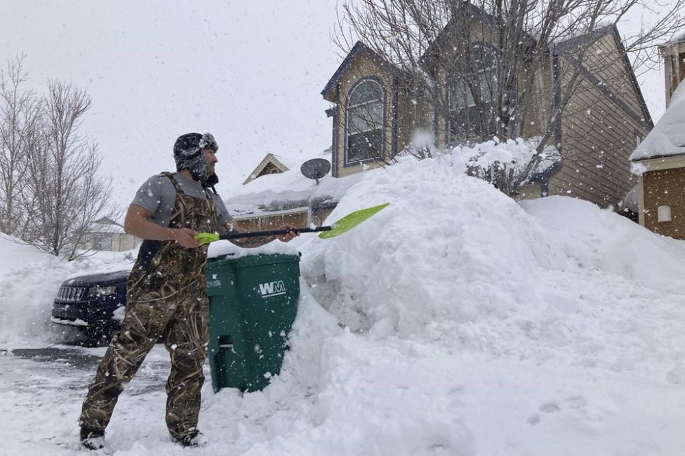 Ronnie Enriquez shovels snow from his driveway Wednesday, March 1, 2023, in Bellemont, Ariz. In Arizona, snow began falling Wednesday morning as the storm moved eastward and was poised to dump as much as 2 feet (60 centimeters) of snow in northern Arizona by Thursday morning. (AP Photo/Felicia Fonseca)