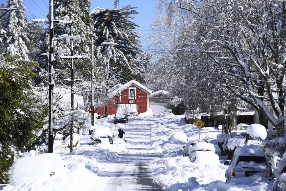 People begin the work of digging their vehicles out of the snow and ice from the recent winter storm along Pleasant Street in Grass Valley, Calif., Wednesday, March 1, 2023. (Elias Funez /The Union via AP)
