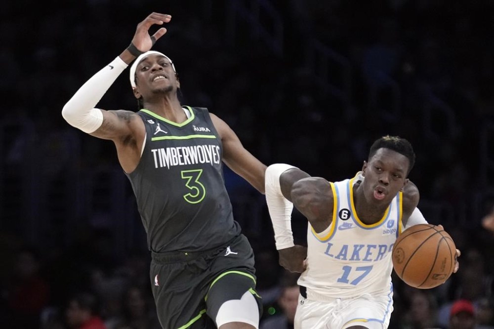 Los Angeles Lakers guard Dennis Schroder (17) dribbles the ball next to Minnesota Timberwolves forward Jaden McDaniels (3) during the first half of an NBA basketball game Friday, March 3, 2023, in Los Angeles. (AP Photo/Marcio Jose Sanchez)