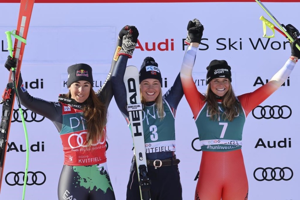 Norway's Kajsa Vickhoff Lie, center, winner of an alpine ski, World Cup women's downhill race, celebrates on the podium with second-placed Italy's Sofia Goggia, left, and third-placed Switzerland's Corinne Suter, in Kvitfjell, Norway, Saturday, March 4, 2023. (AP Photo/Marco Trovati)