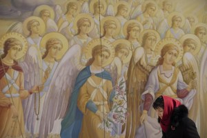 A woman passes the walls of the St. Michael's Golden-Domed Monastery in Kyiv, Ukraine, Sunday, March 5, 2023. (AP Photo/Vadim Ghirda)