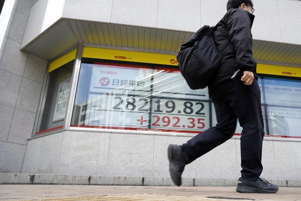 A person walks in front of an electronic stock board showing Japan's Nikkei 225 index at a securities firm Monday, March 6, 2023, in Tokyo. Shares advanced Monday in Asia after strong data on the U.S. economy sent Wall Street to its best close in six weeks.(AP Photo/Eugene Hoshiko)