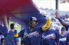 Atlanta Braves Ronald Acuna Jr. is greeted in the dugout after driving in a run during the sixth inning of a spring training baseball game against the Minnesota Twins in North Port, Fla., Saturday, March 4, 2023. (AP Photo/Gerald Herbert)