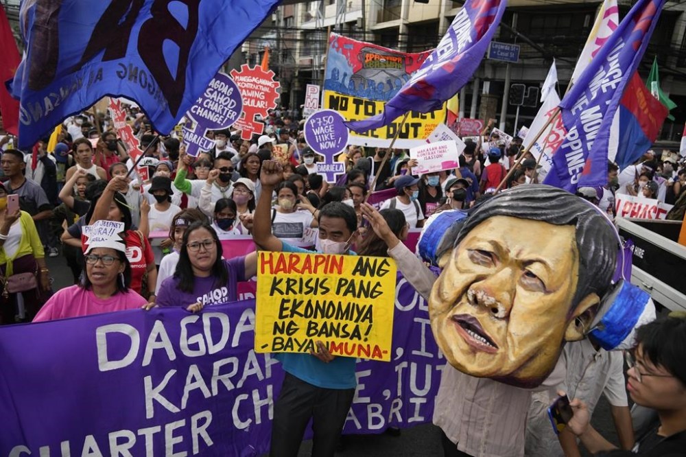 A protester wears a mask of Philippine President Ferdinand Marcos Jr. during a rally near the Malacanang presidential palace in Manila, Philippines as they mark International Women's Day on Wednesday, March 8, 2023. (AP Photo/Aaron Favila)